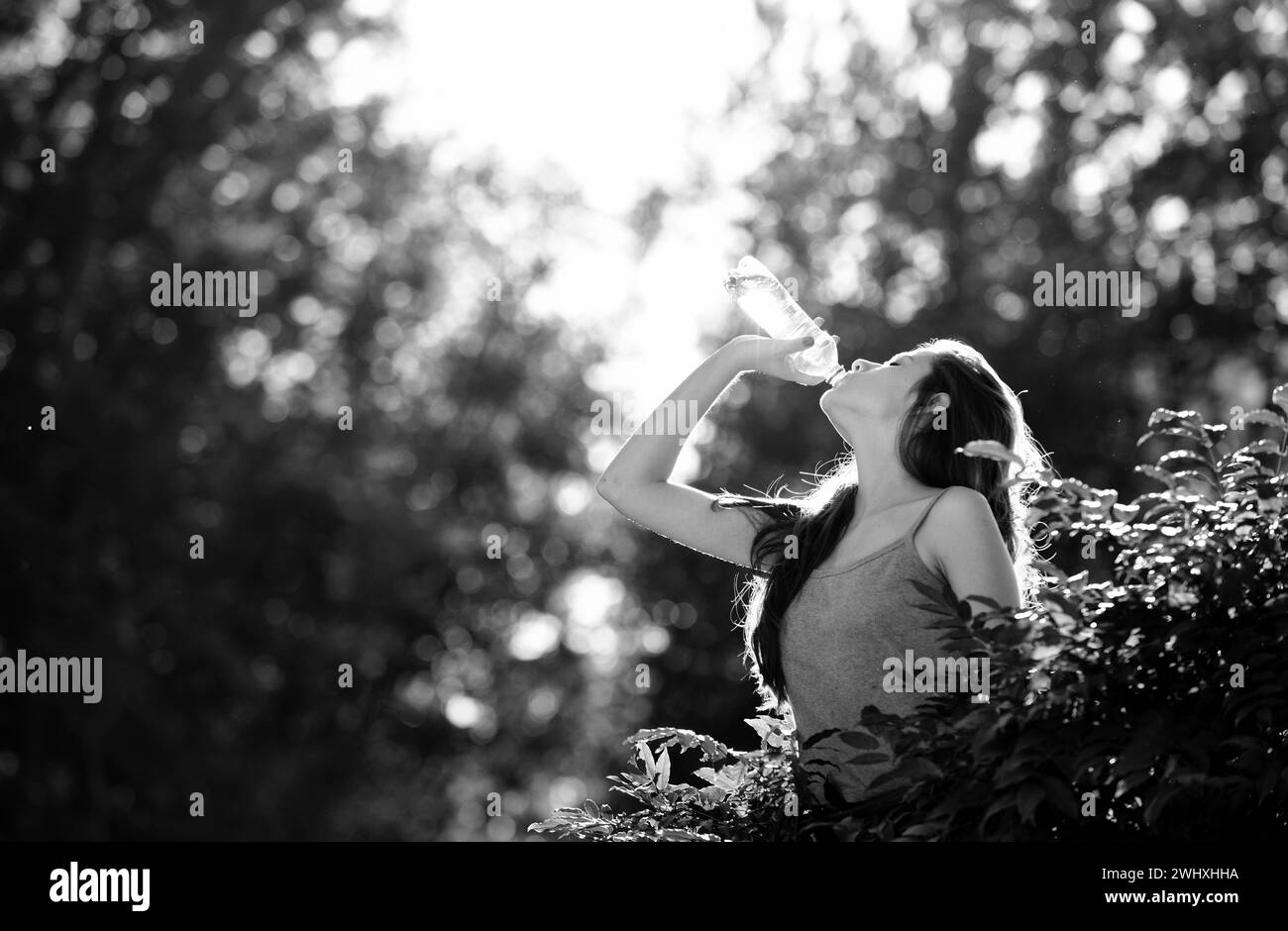 Healthy woman drinking water from bottle. Stay hydration concept. Unhidrated. Unity with nature, outdoor. Stock Photo