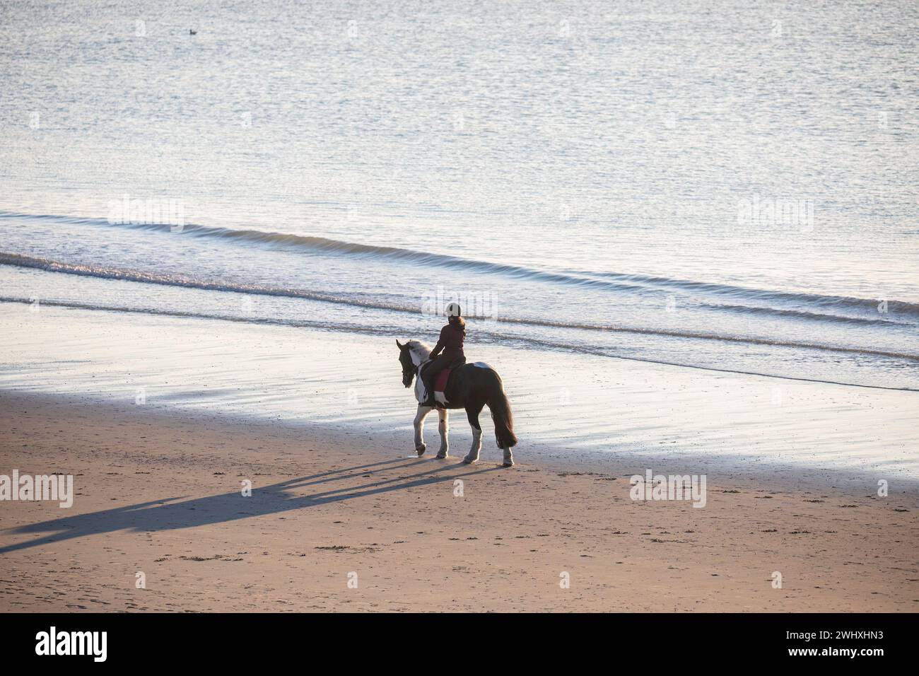 Woman riding horse on sand beach Stock Photo