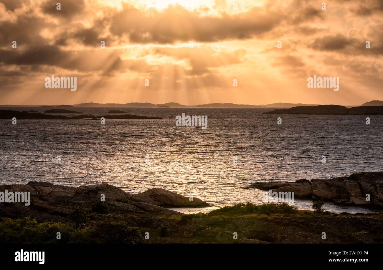 Dramatic sunbeams over sea shore Stock Photo
