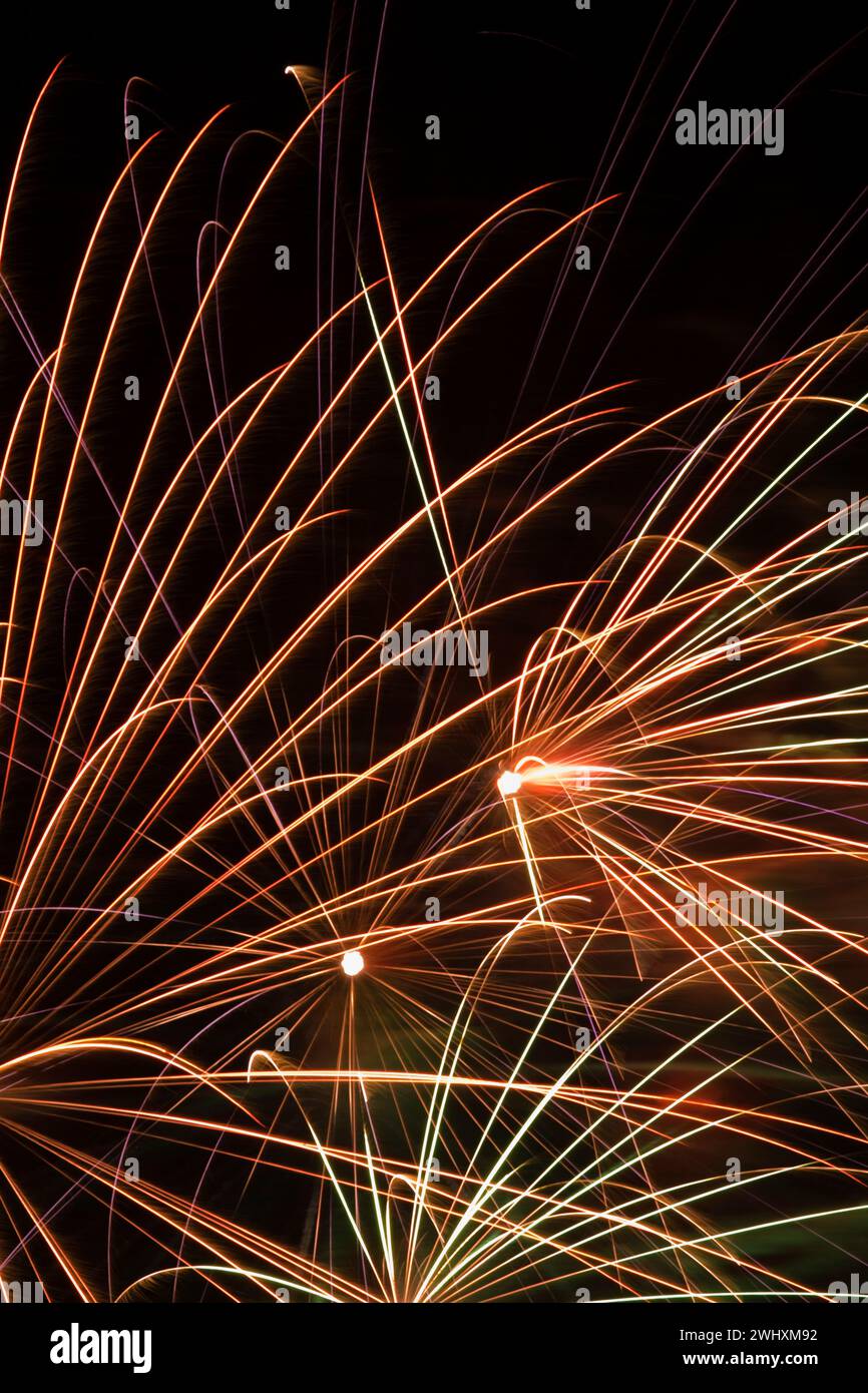 Gold, white, red and green fireworks in night sky. Stock Photo