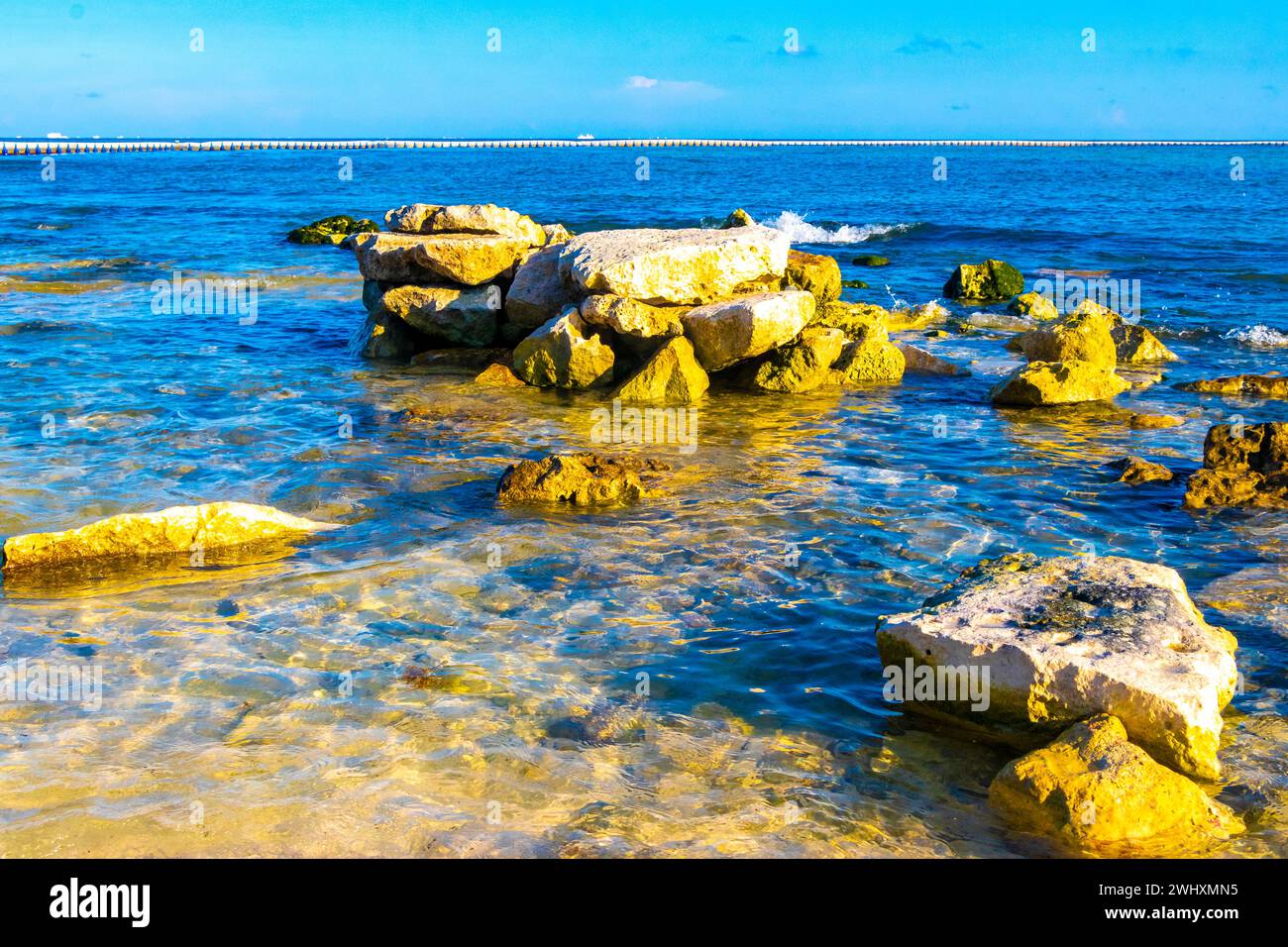 Stones rocks and corals in turquoise green and blue water on the beach ...