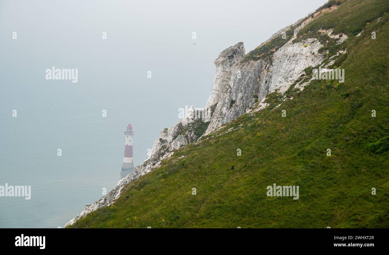 Beachy head lighthouse at the edge of white chalk cliff. Safety warning in the ocean Stock Photo