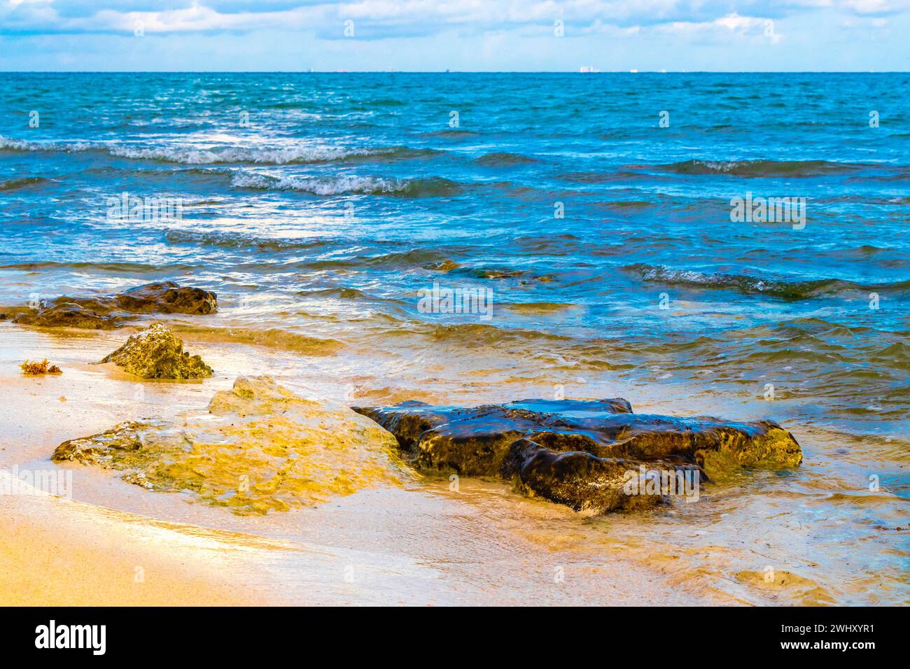 Stones rocks and corals in turquoise green and blue water on the beach ...