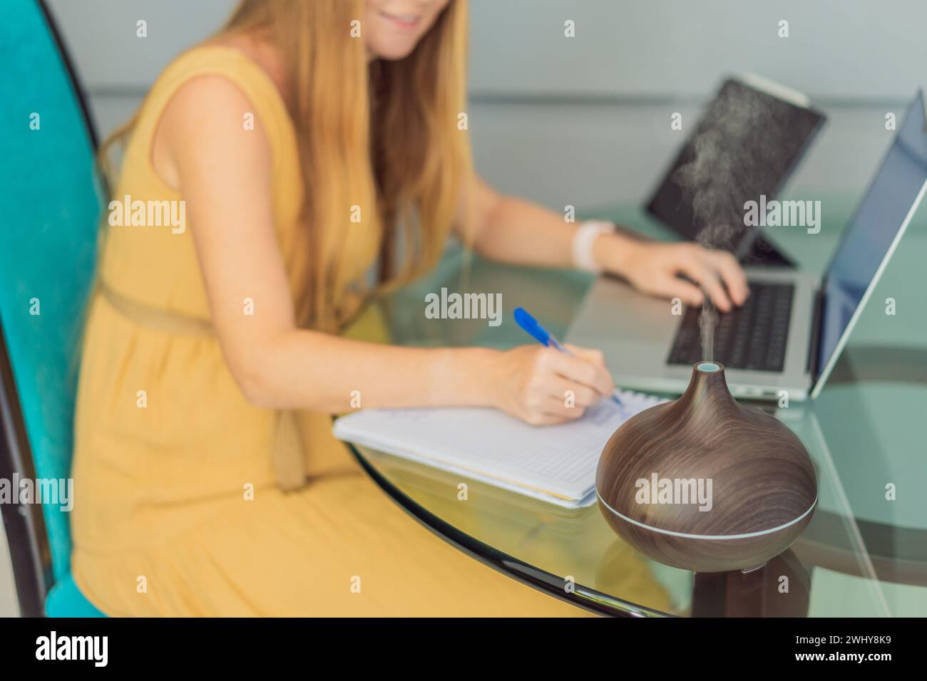 Expectant woman enhances work environment, using an aroma diffuser for
