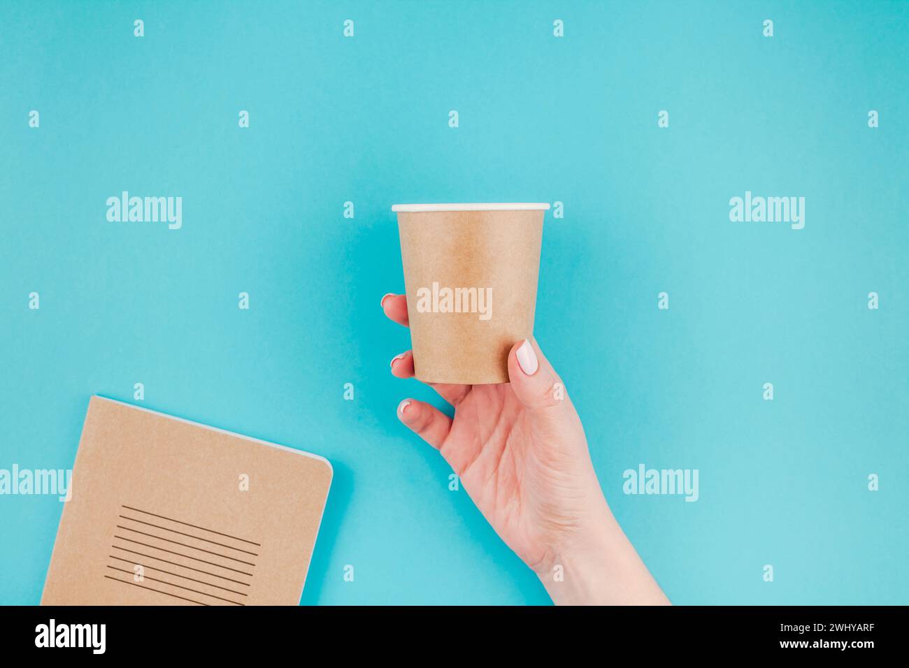 Woman hand with craft paper cup and notebook Stock Photo - Alamy