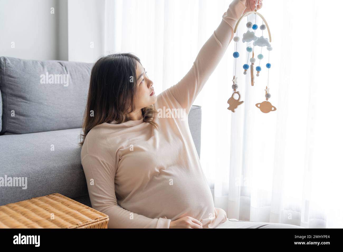 Pregnant asian woman getting ready for the maternity hospital preparing and planning baby clothes for new babyÂ of pregnancy pac Stock Photo