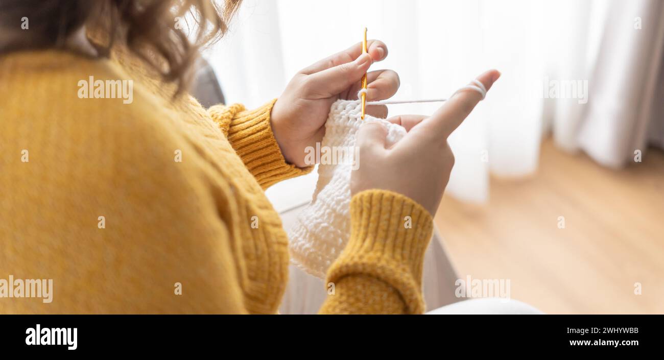 Pregnant asian woman preparing for baby knitting baby winter clothes Pregnancy mother crochet kid cloth at home Positive life mo Stock Photo