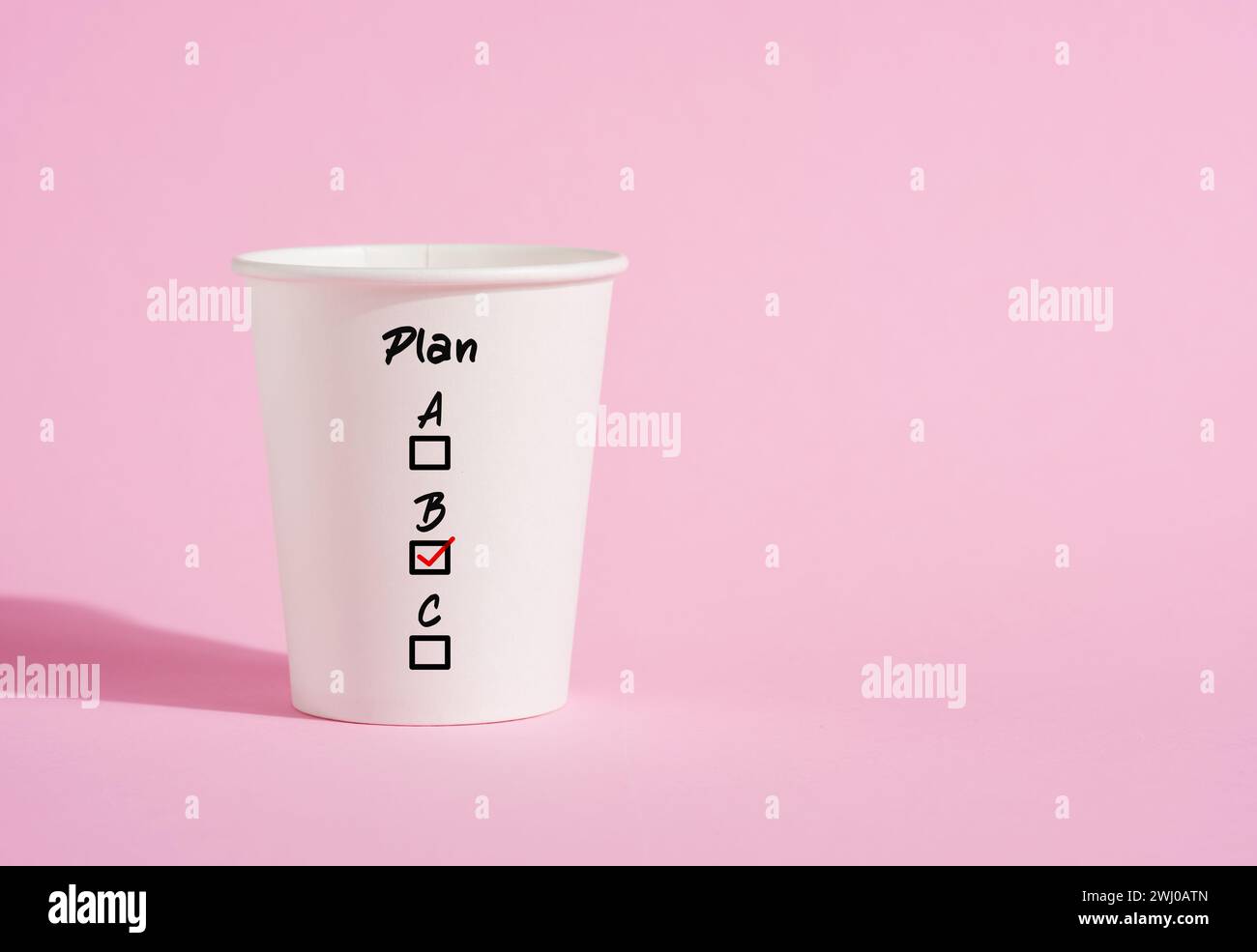 Plan A, B and C on a paper coffee cup on pink background. Business planning and choosing a strategy plan out of the alternative options. Stock Photo