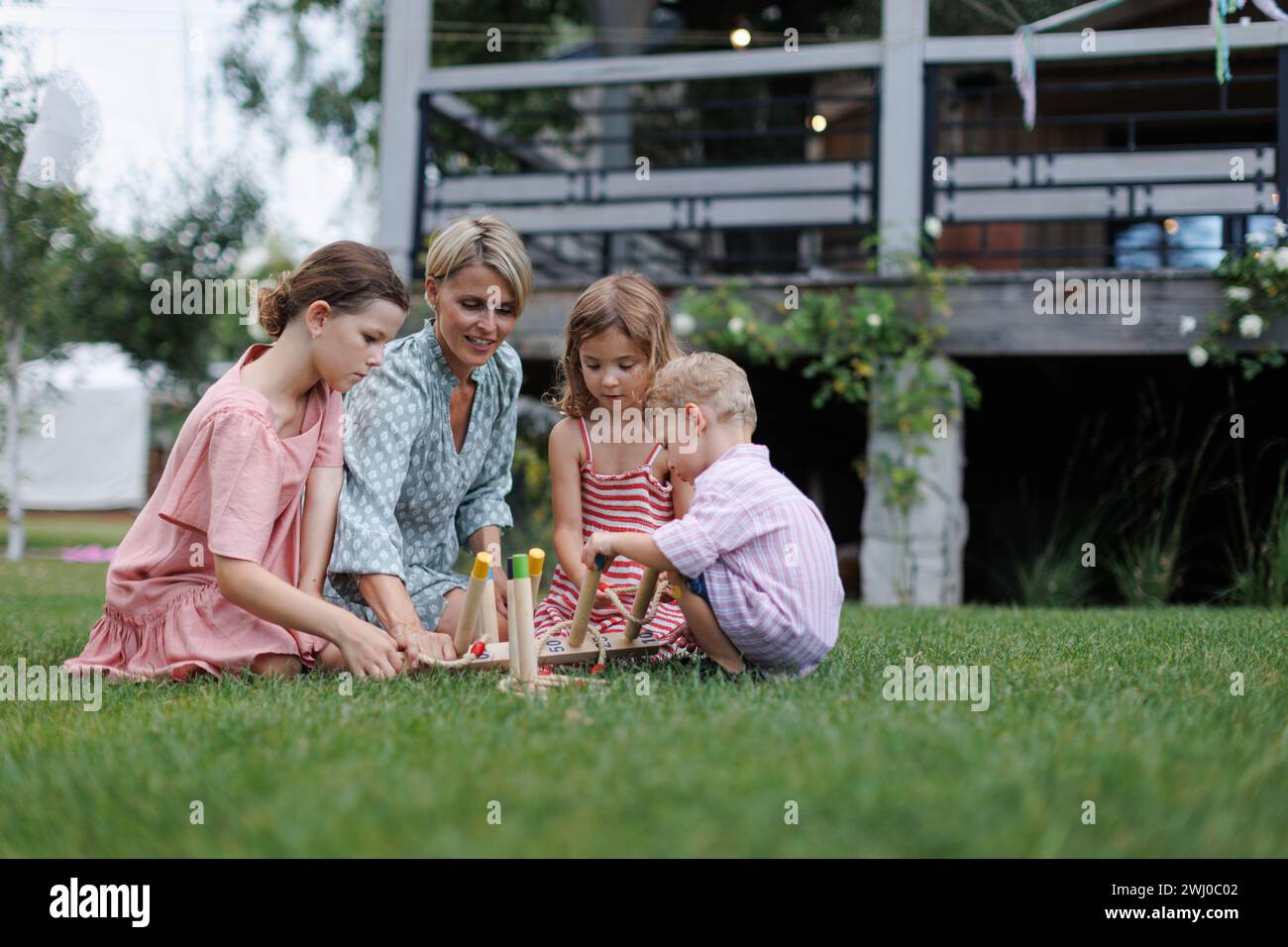 Woman playing with kids in the garden outdoor garden games sitting on