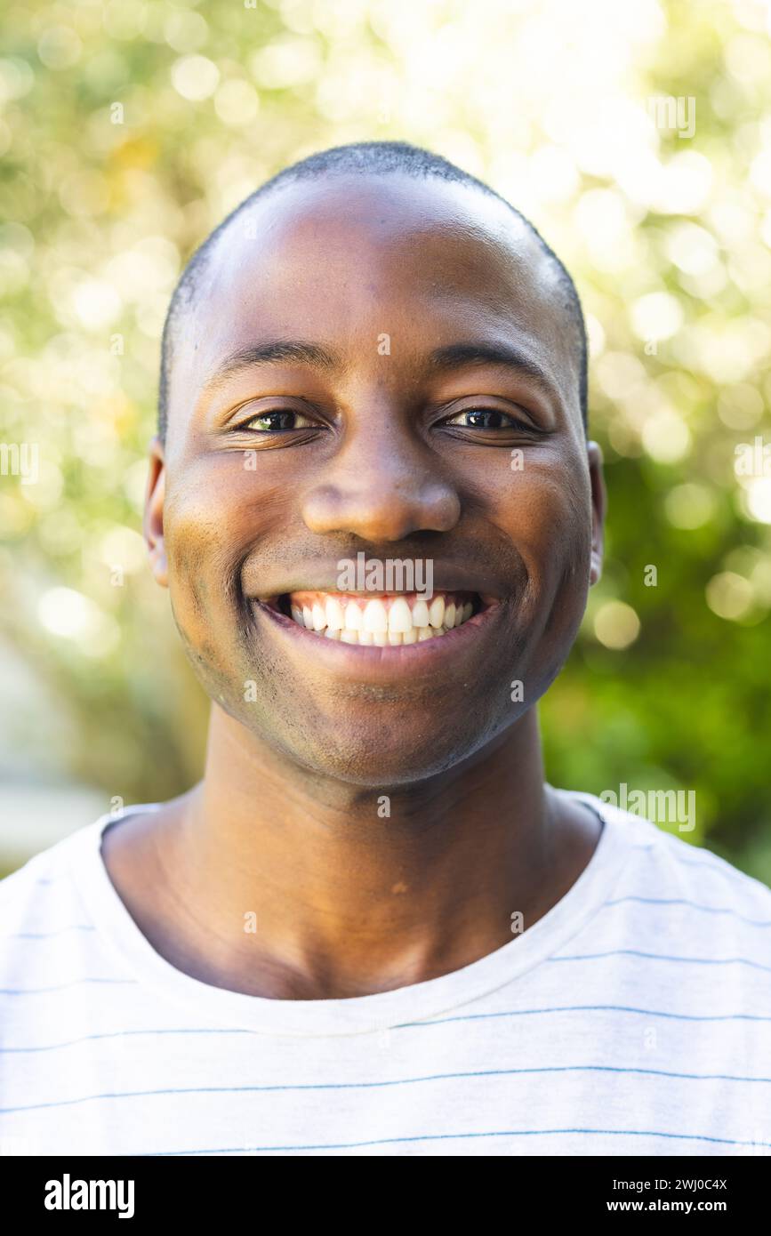 Young African American man smiles brightly outdoors Stock Photo