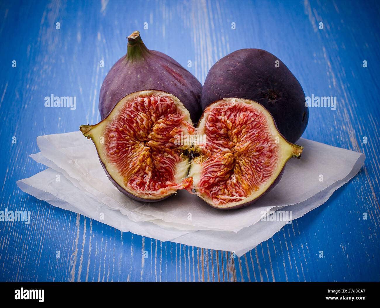 Three ripe figs on blue background Stock Photo