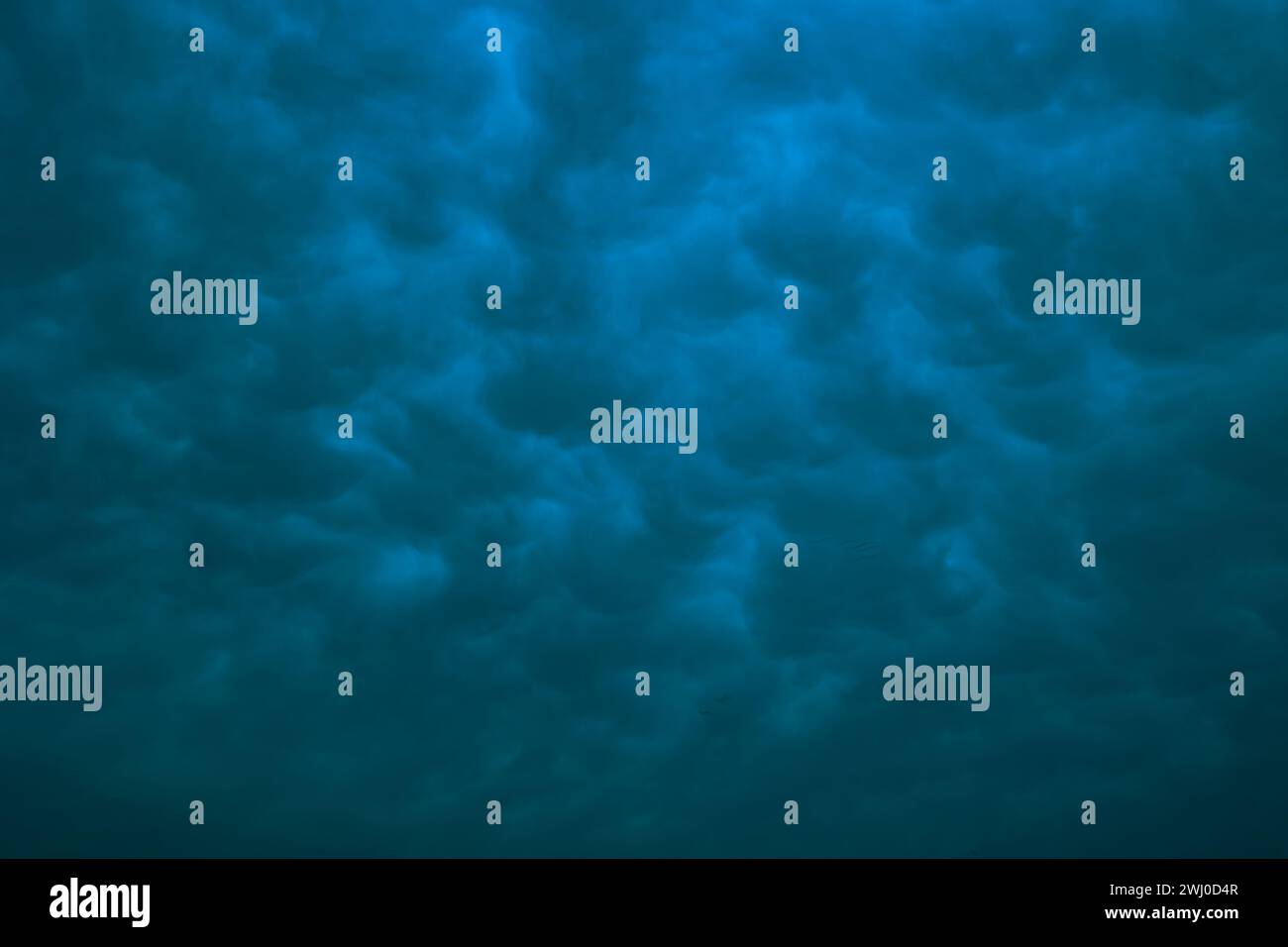 Dramatic mammatus clouds in moody view. Cloudscape background. Stock Photo