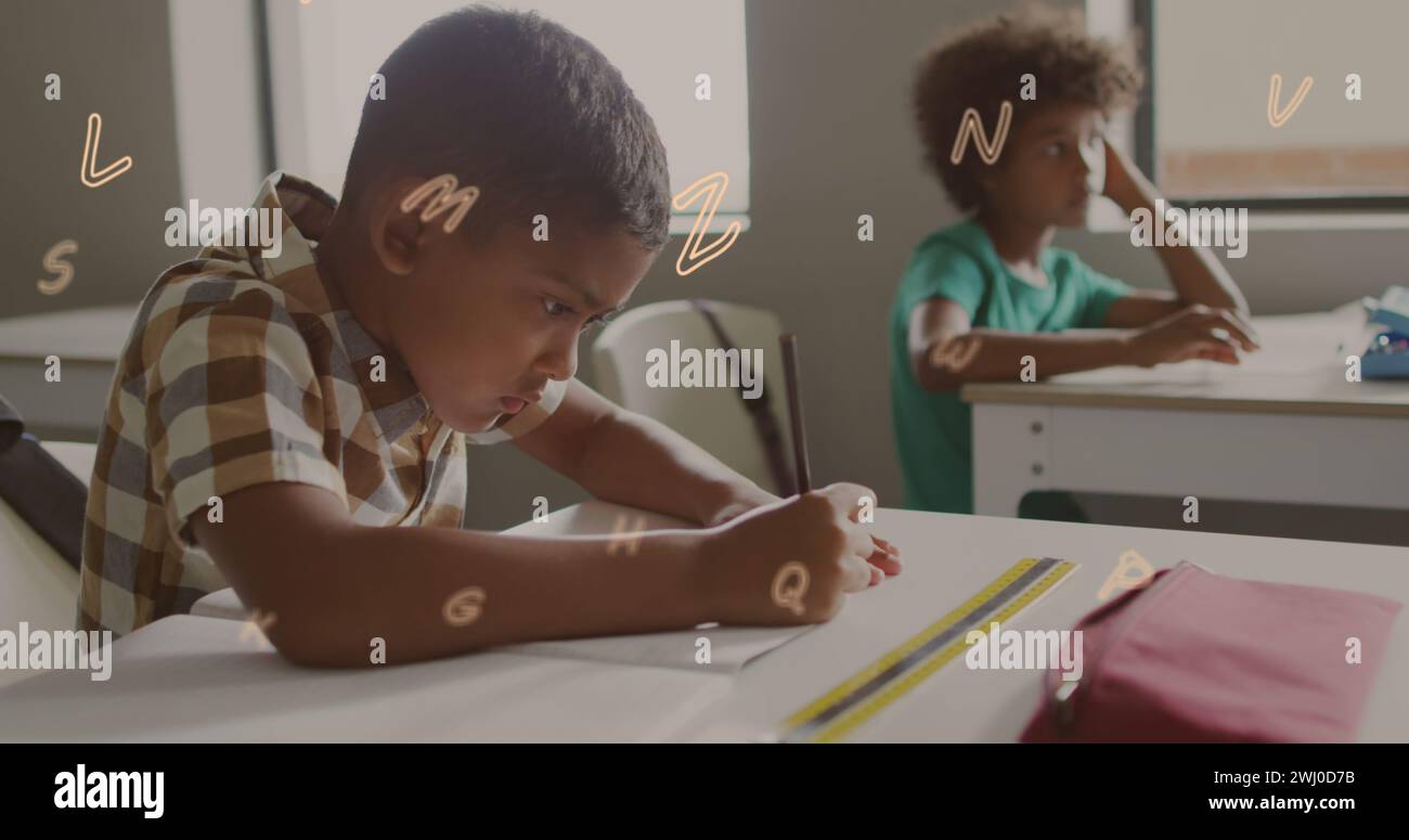 Image of letters floating over bust african american schoolboy writing at desk in class Stock Photo