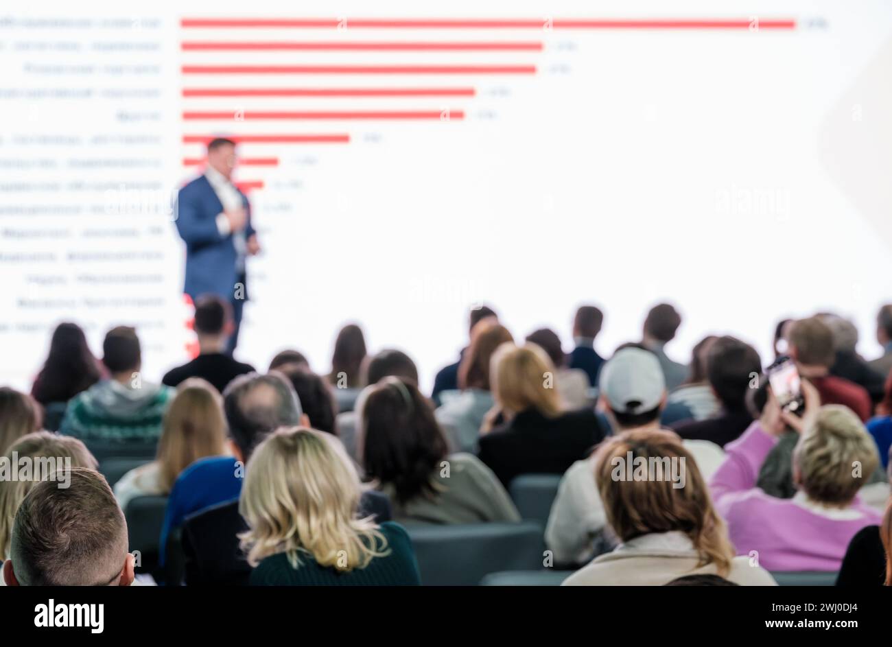 Blurred speaker engaging audience during a conference presentation in a ...