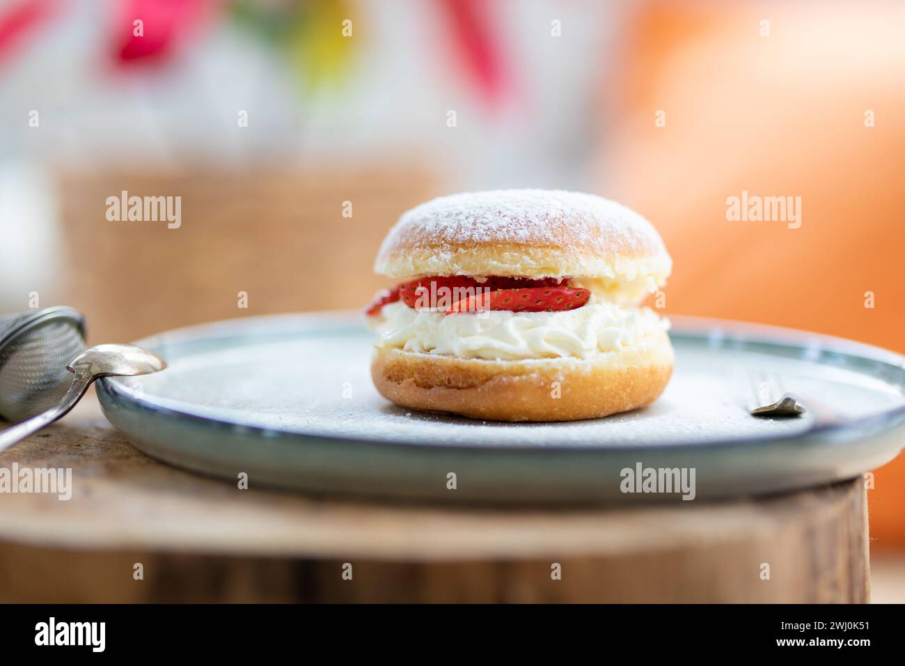 A decadent Berliner pastry oozing with luscious cream and adorned with fresh strawberries Stock Photo