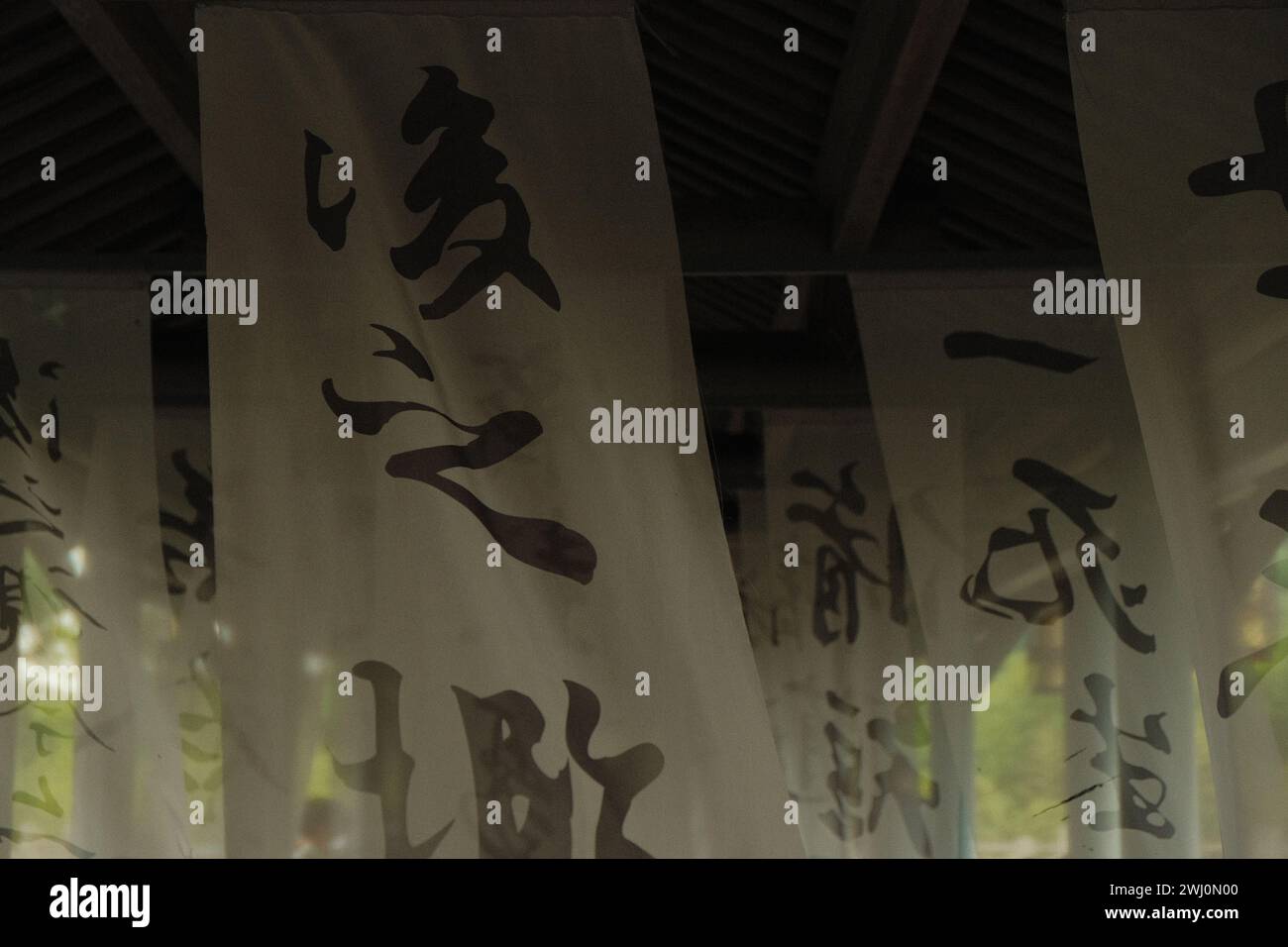 A Chinese calligraphy written on white gauzes hanging from the ceiling of a traditional chinese pavilion Stock Photo