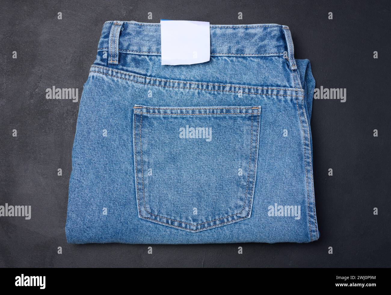 Folded blue jeans on a black background, top view Stock Photo