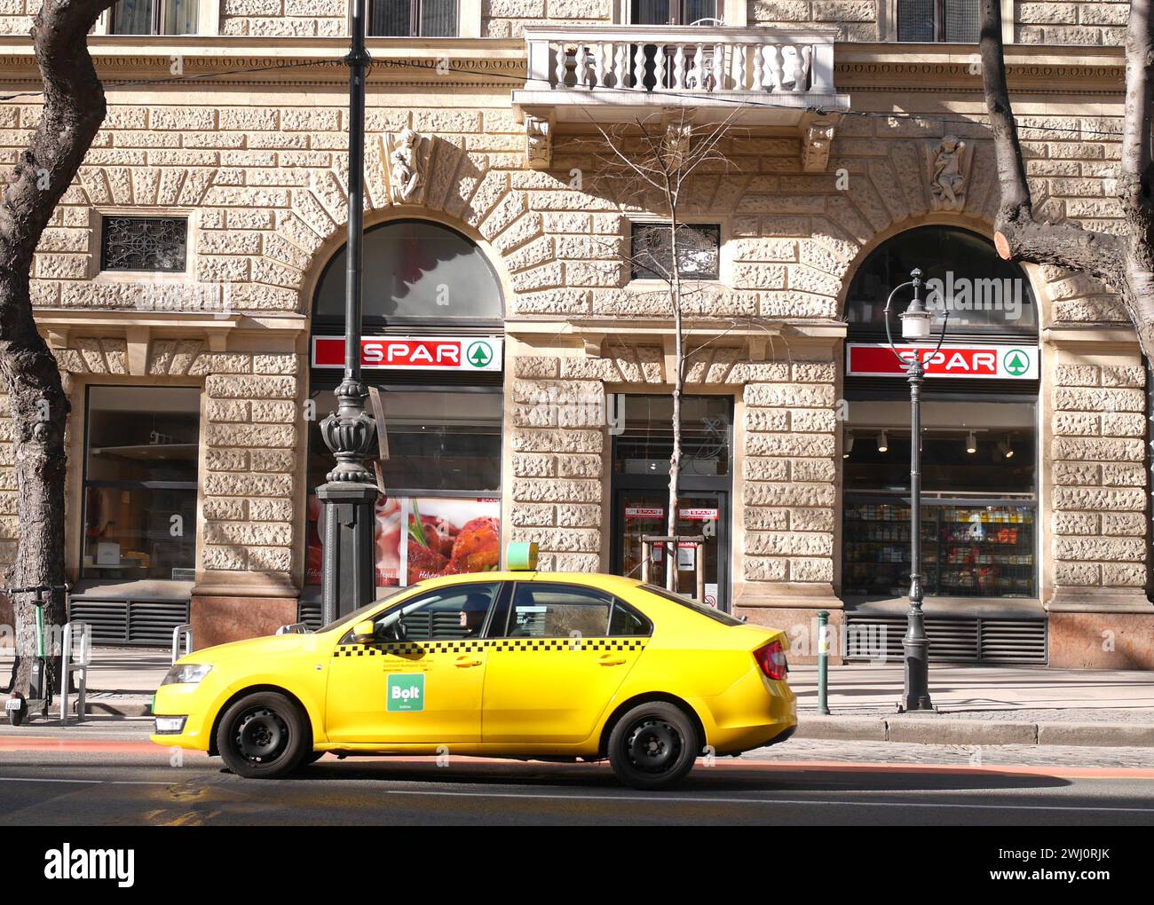 Spar supermarket with a yellow taxi driving past, Andrassy ut, Andrassy Street,  Budapest, Hungary Stock Photo