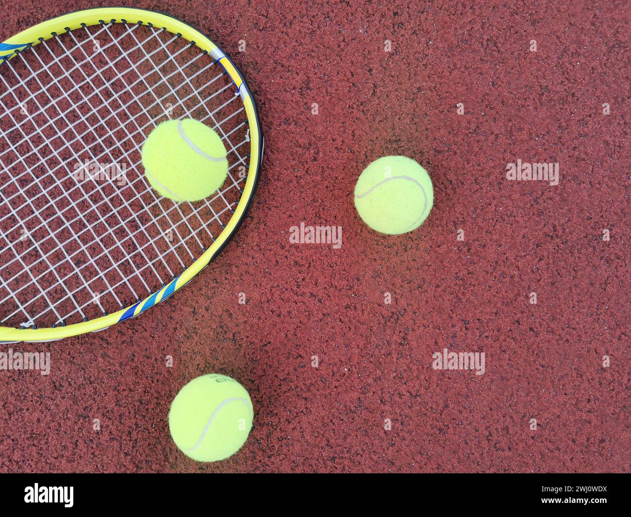 yellow tennis balls and racquet on hard tennis court surface, top view ...
