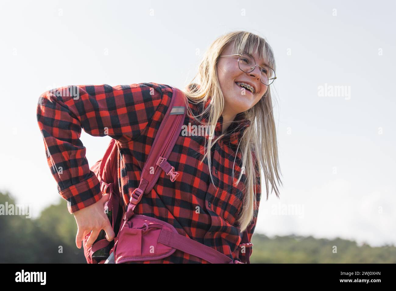 Female hiker with a backpack walking and following the trail uphill ...