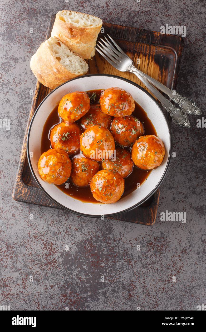 Chicken meatballs in honey glaze and spicy sauce close-up in a bowl on the table. Vertical top view from above Stock Photo