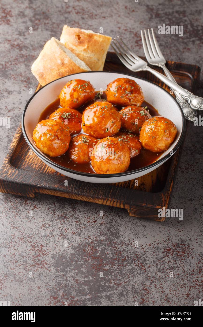 Chicken meatballs in honey glaze and spicy sauce close-up in a bowl on the table. Vertical Stock Photo