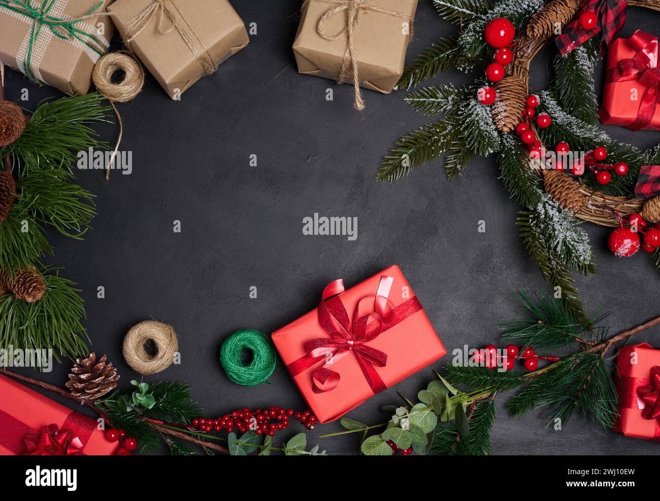 Christmas wreaths, fir branches and gifts on a black background. View ...
