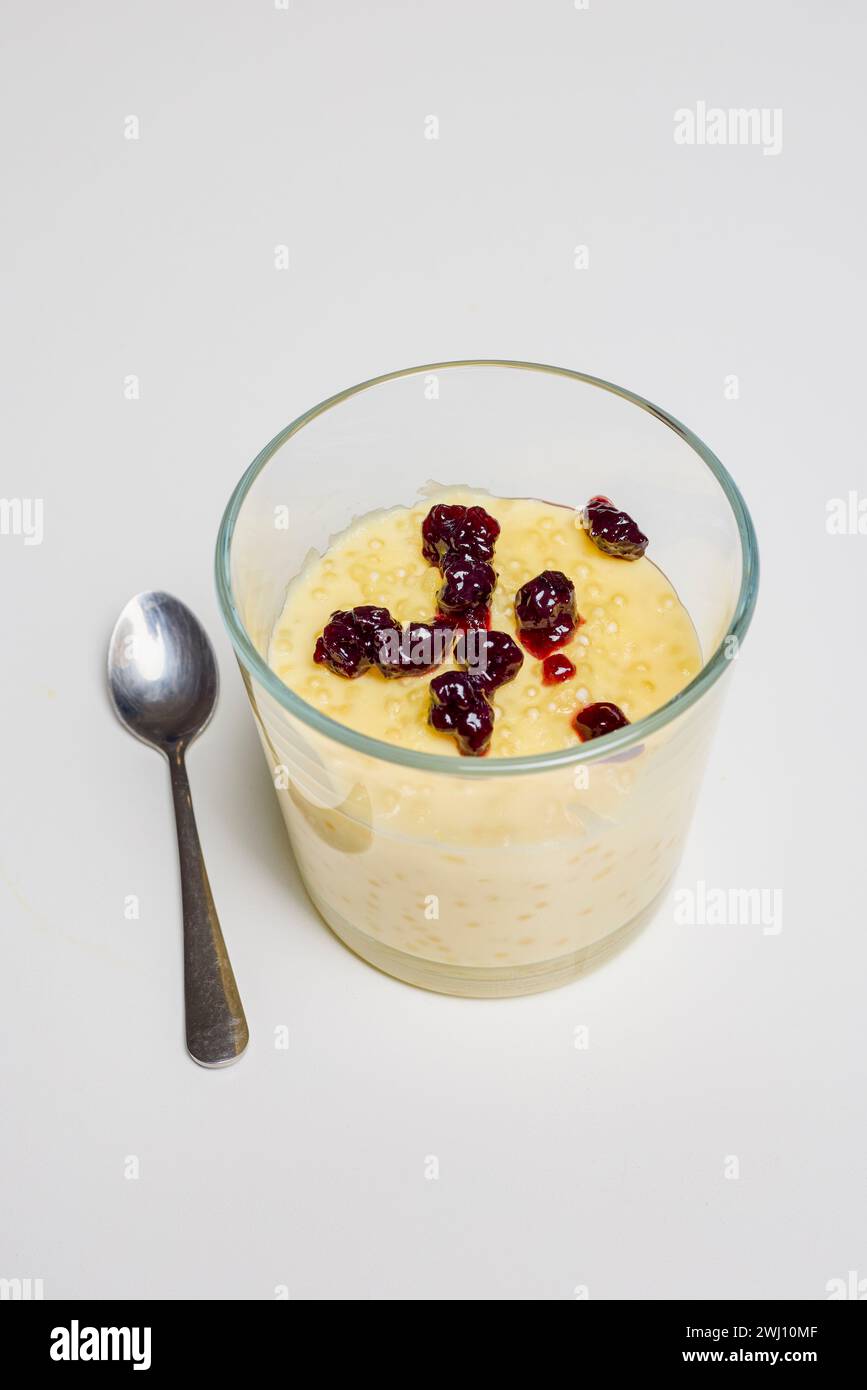 a glass bowl with dessert, tapioca pudding with vanilla and blueberry jam. Stock Photo