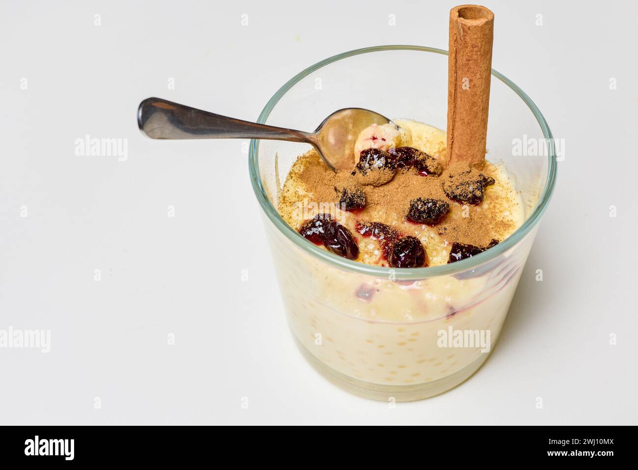 a glass bowl with dessert, tapioca pudding with vanilla and blueberry jam. Stock Photo