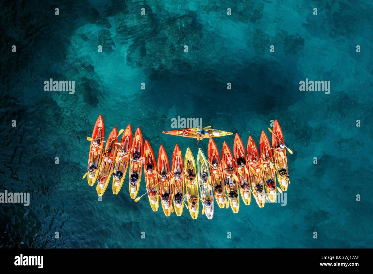 Row of red and yellow kayaks on the turquoise sea. Top view Stock Photo