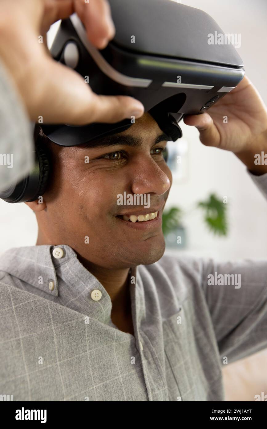 Happy biracial man using vr headset at home Stock Photo