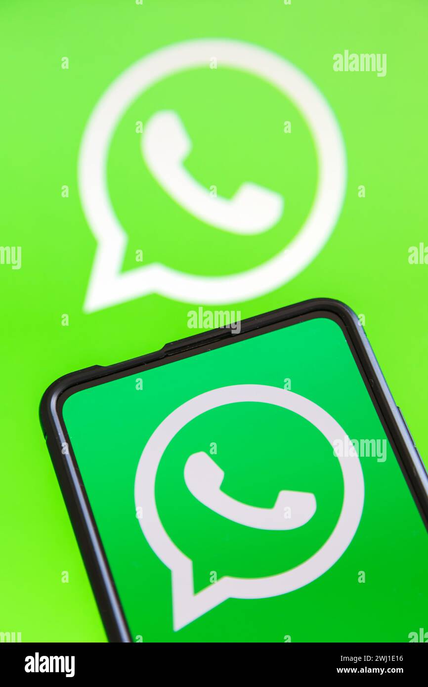 WhatsApp logo messenger app on a cell phone and computer screen Stock Photo