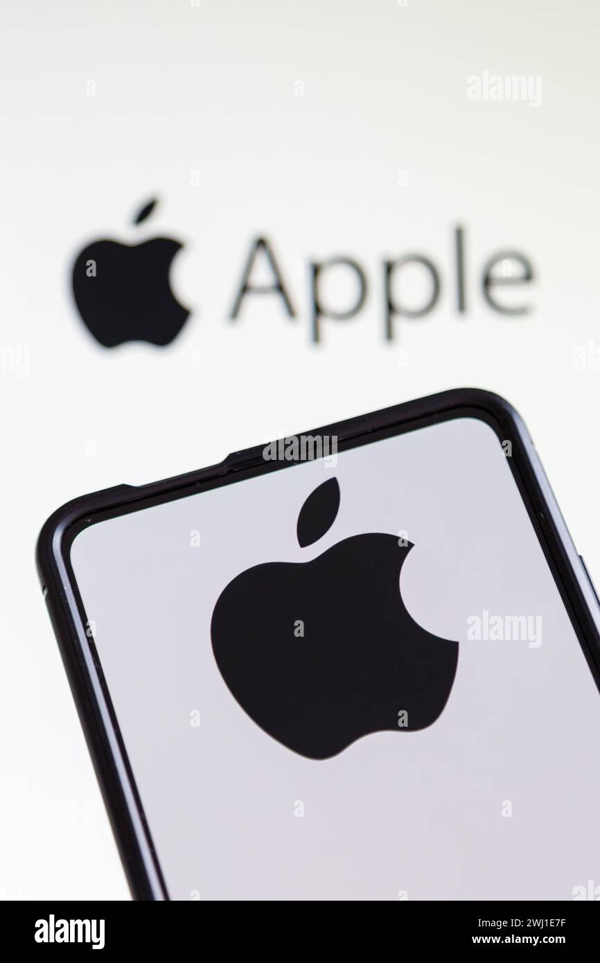 Apple logo of the computer and smartphone manufacturer on a cell phone and screen Stock Photo