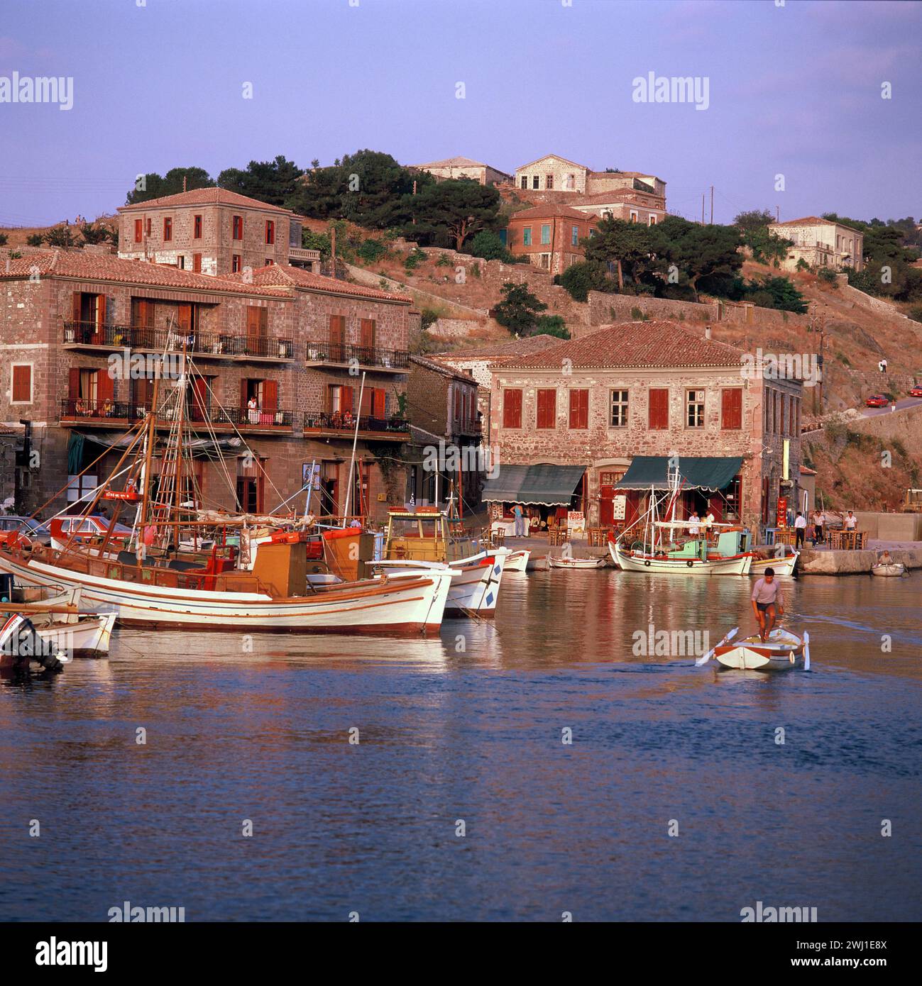 Greece. Lesbos Island. Molyvos. Waterfront café & moored boats. Stock Photo
