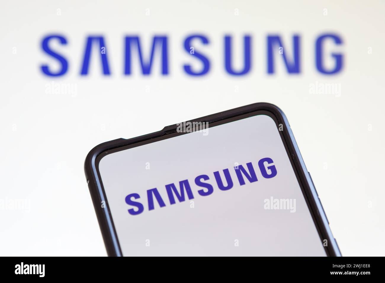 Samsung logo of the TV and smartphone manufacturer on a cell phone and screen Stock Photo