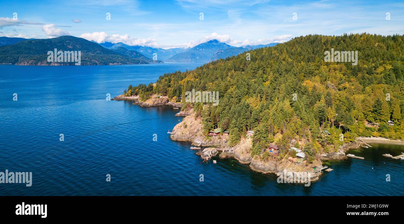 The vibrant blue waters contrast with majestic green mountains. Canada Stock Photo