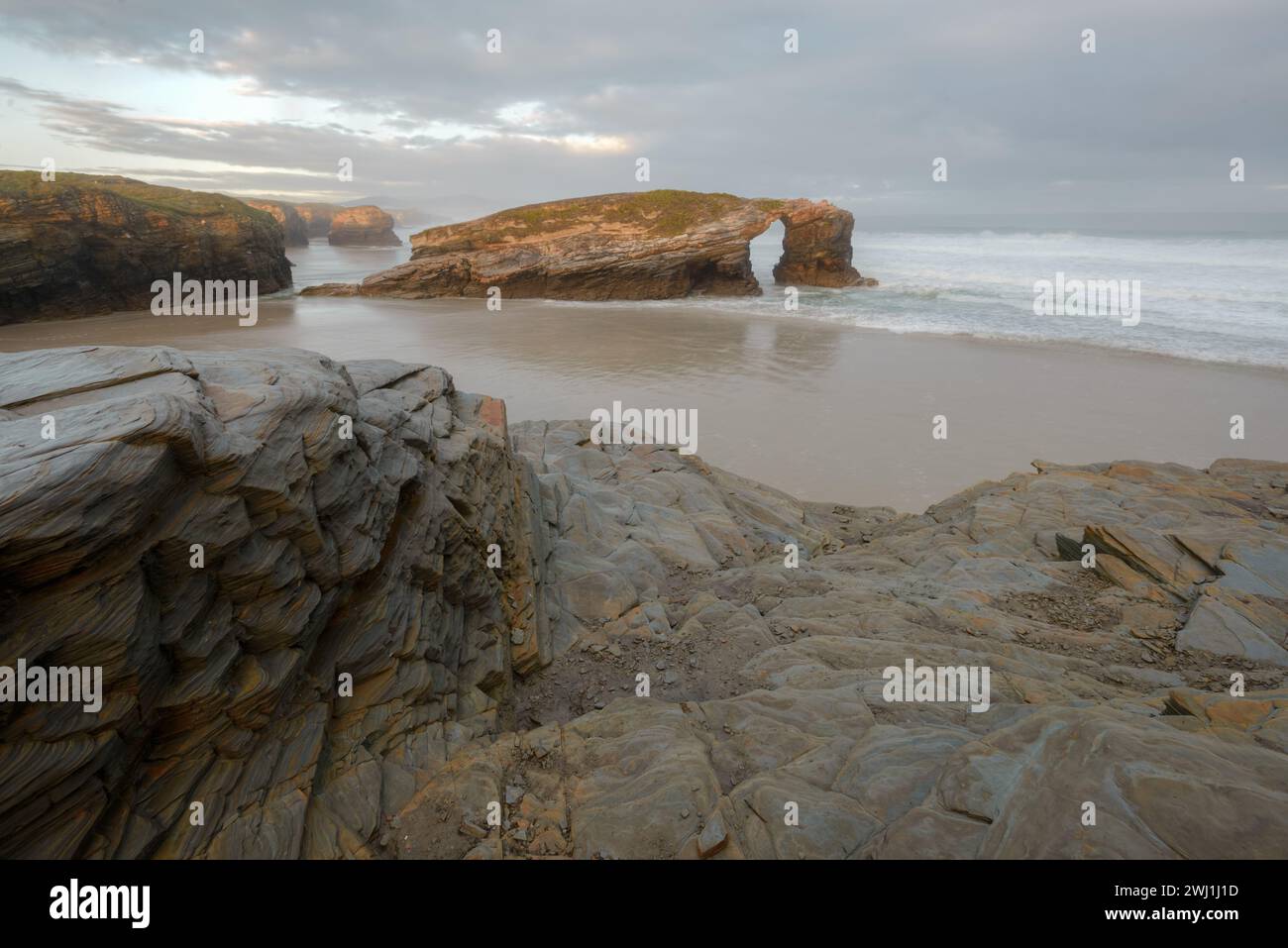 The famous rocky arch visible at low tide on As Catedrais beach in Ribadeo Lugo Galicia Stock Photo