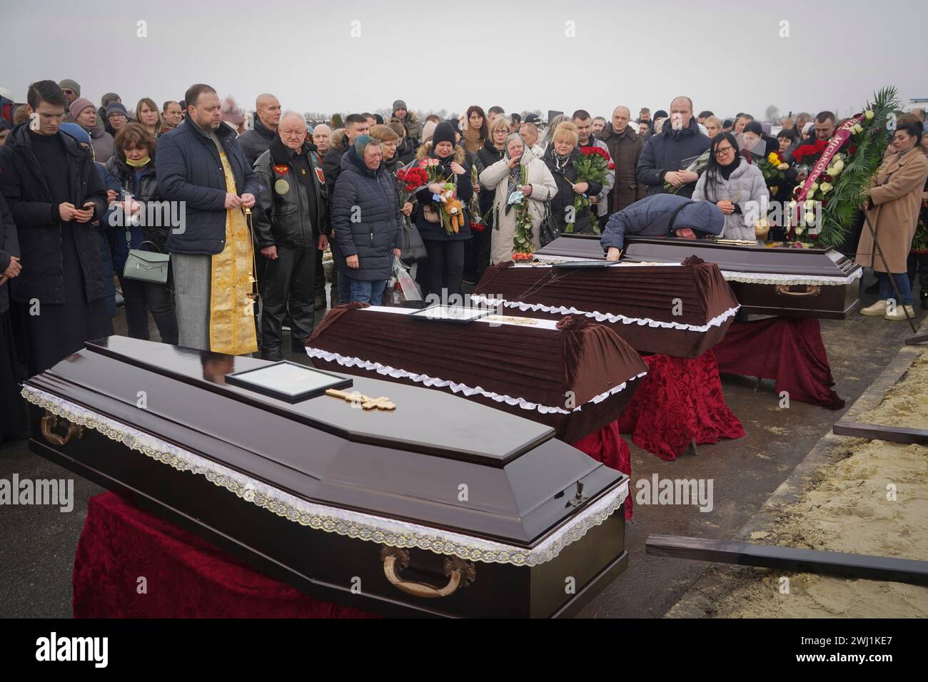 People mourn over the coffins of a family killed in a fire when Russian ...