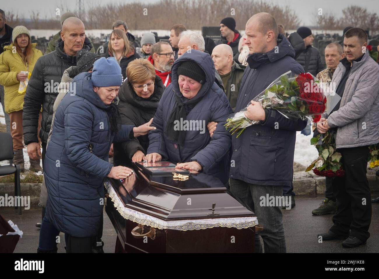 People mourn over the coffins of a family killed in a fire when Russian ...