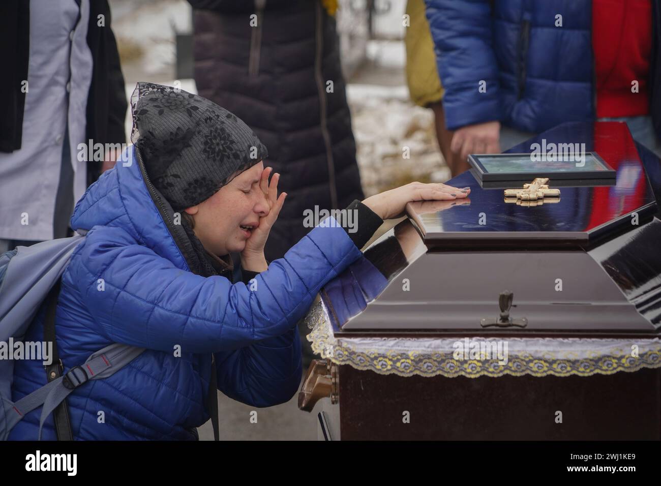 People mourn over the coffins of a family killed in a fire when Russian ...