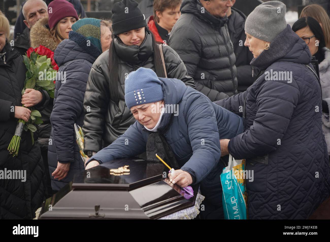People mourn over the coffins of a family killed in a fire when Russian ...