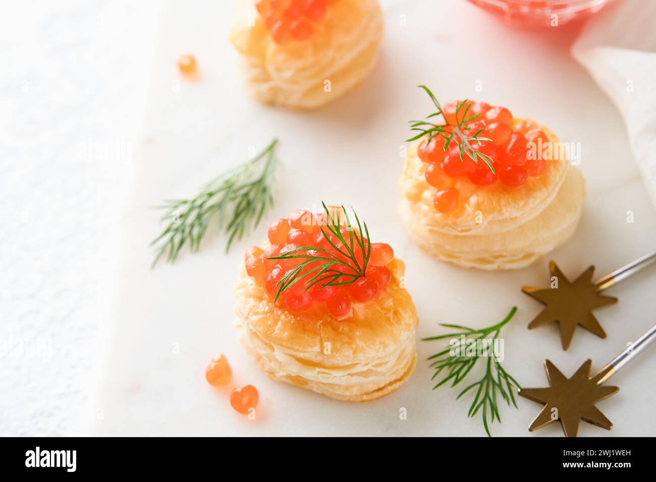 Salmon red caviar toast. Christmas canape or toast with red caviar on white plate on light background. Idea to xmas snack. Gourmet food. Texture of ca Stock Photo