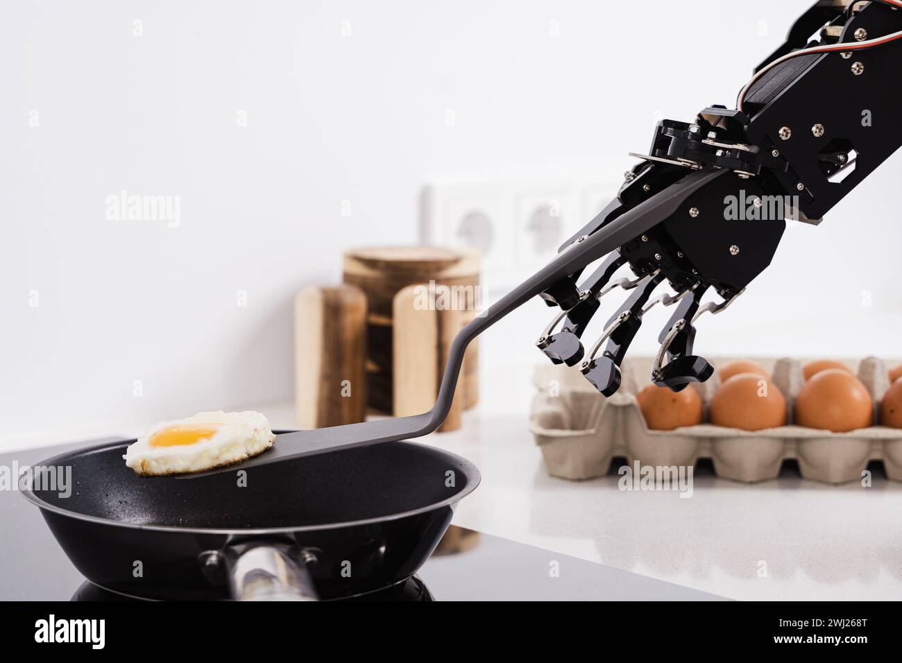 Real robot hand and frying pan with fried egg. Concepts of AI development and robotic process automation Stock Photo