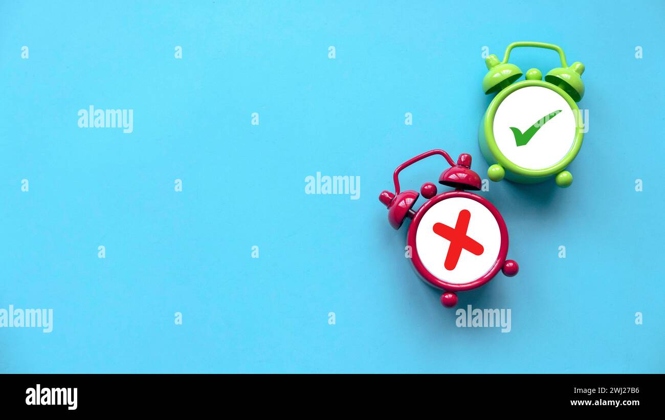 Concept of evaluation. True or false symbol. Accepted or rejected. Yes or no icon over a an alarm clock on a blue background with copy space. Stock Photo