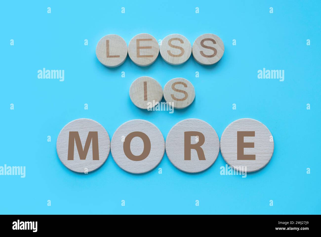 Less is more in alphabet over a blue background Stock Photo - Alamy
