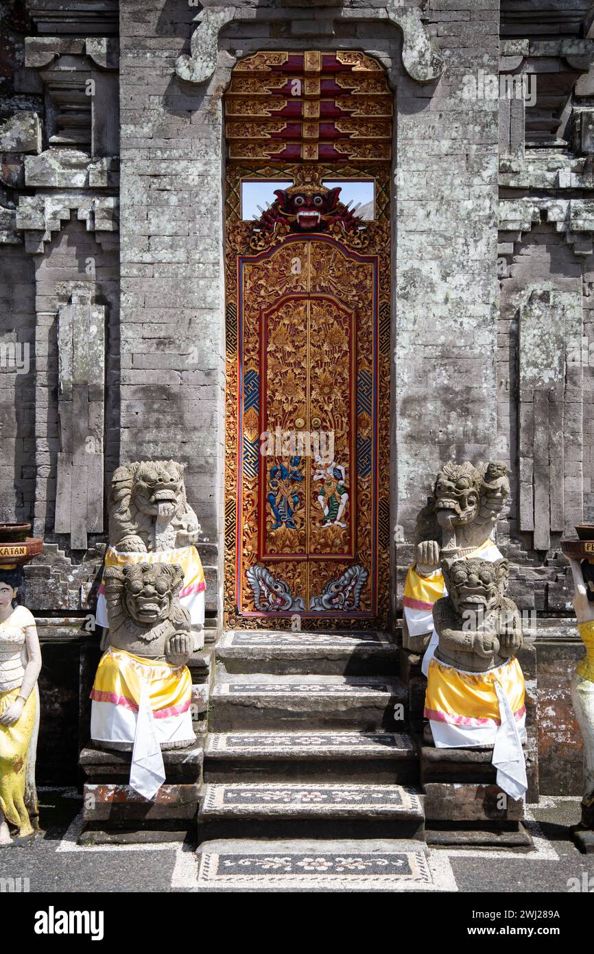 Red wooden door, covered with carvings and religious patterns Stock Photo