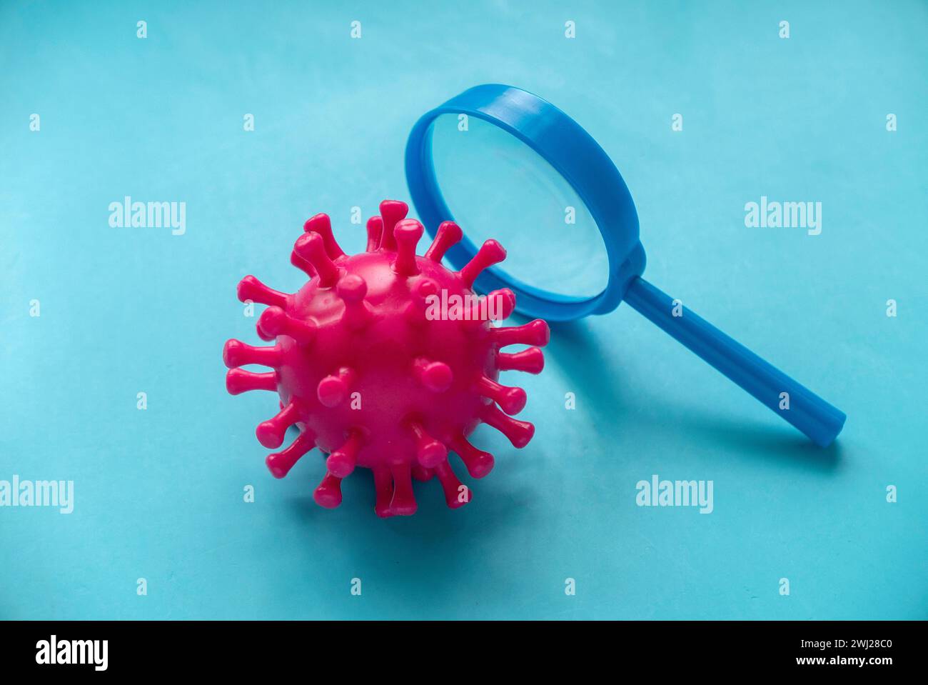 Virus model with magnifying glass Stock Photo - Alamy