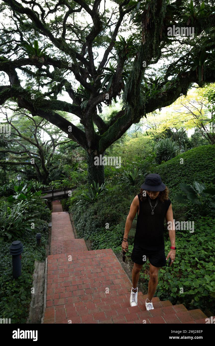 Male tourist, with black vest, walking at Fort Canning Park Stock Photo