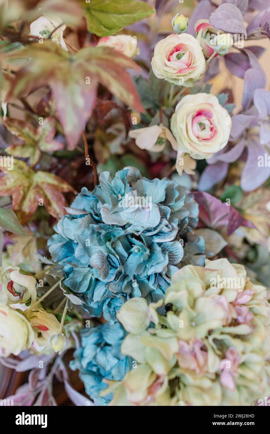 Faux flower arrangement with hydrangeas and roses in muted colors Stock Photo