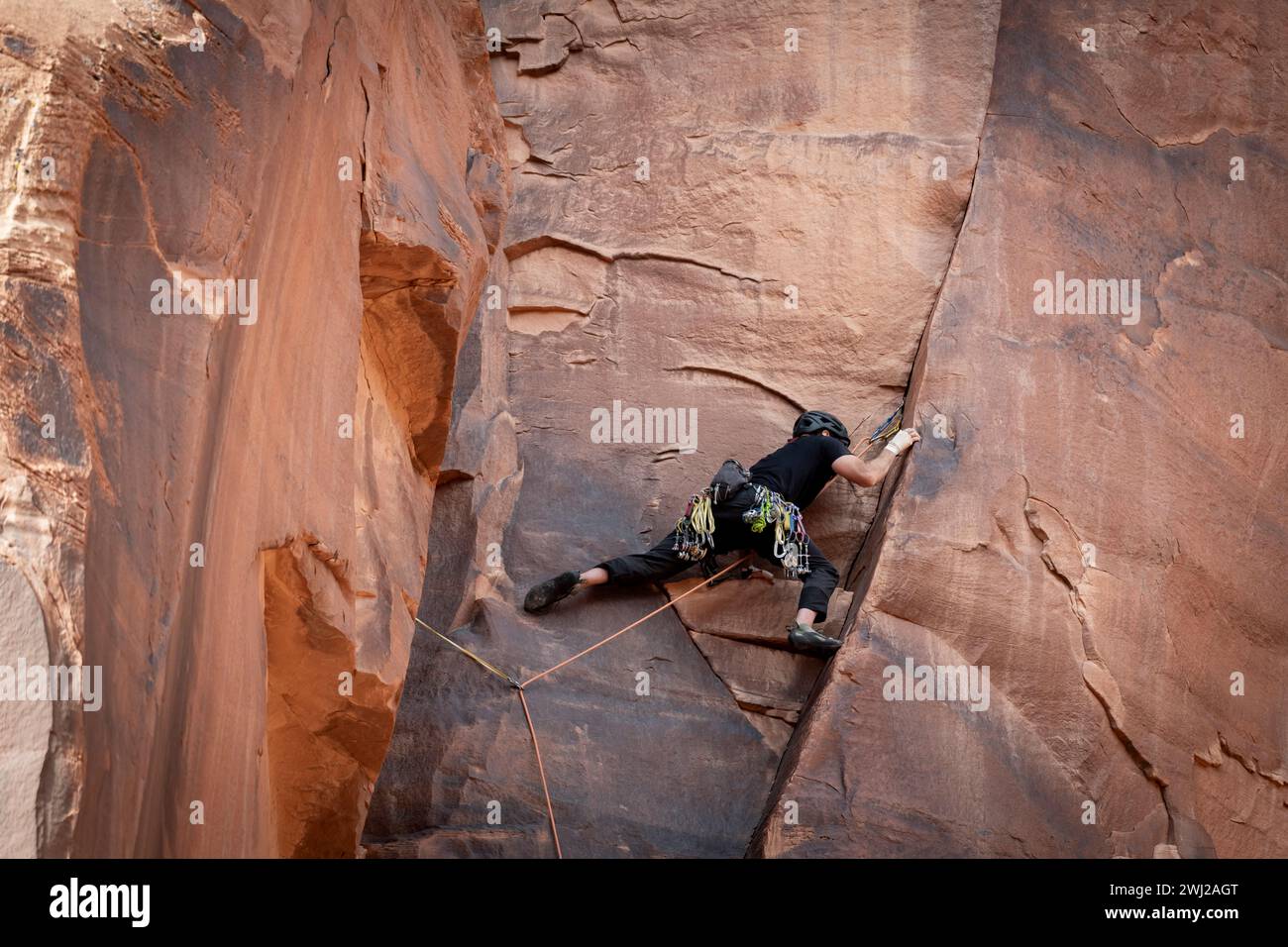 Low angle view of man climbing cliff at desert Stock Photo